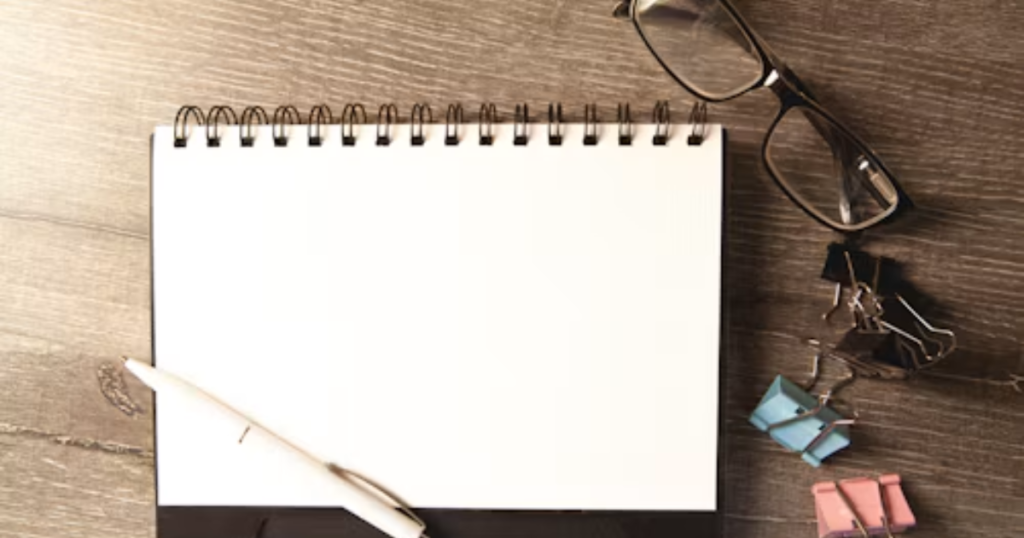 Organized notebook and pen on a clean desk representing focus and consistent habits