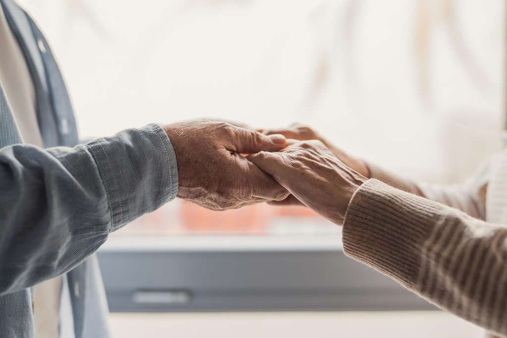 Two people holding hands, symbolizing love, acceptance, and emotional support.